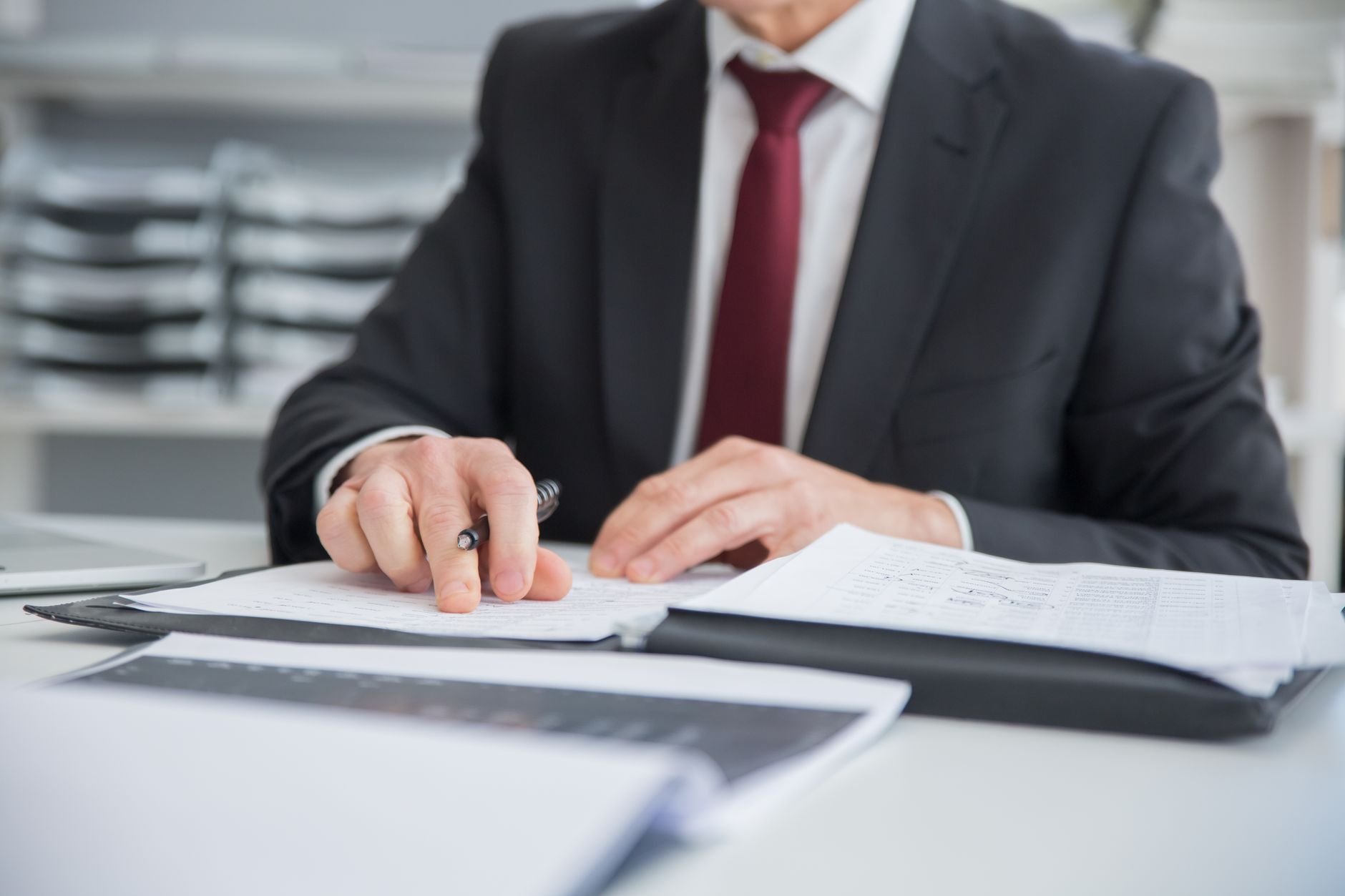 Close-up of a businessman reviewing documents at an office desk.